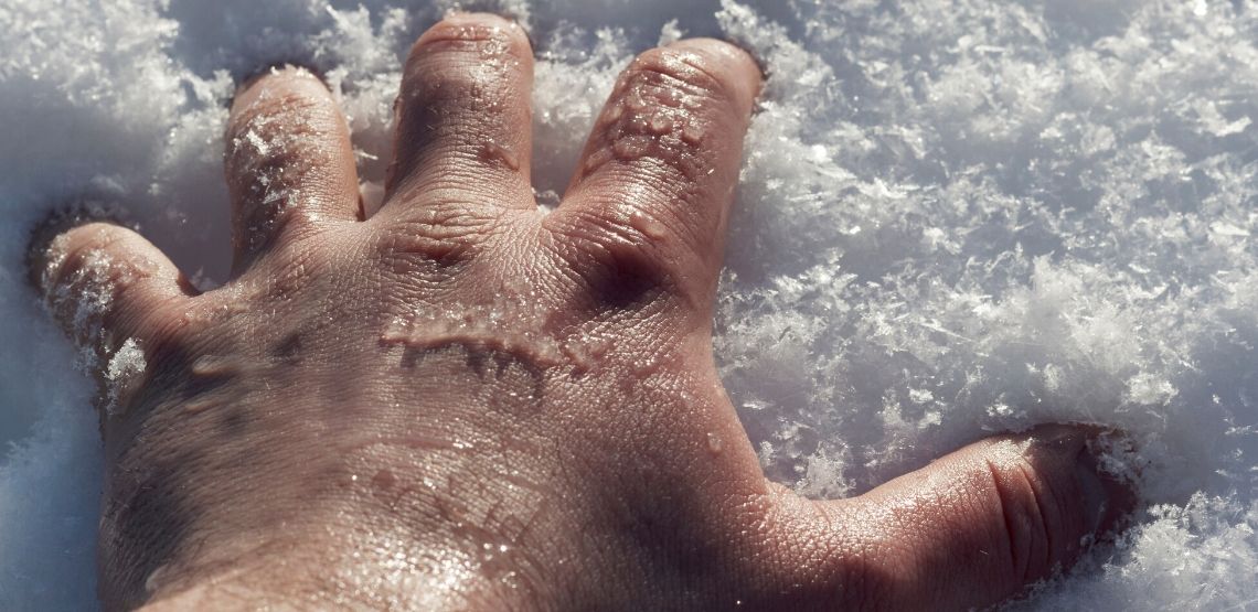 Someone sticking their hand in snow.